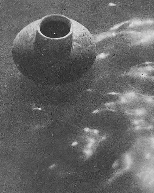 A black and white photo of a vessel floating in water